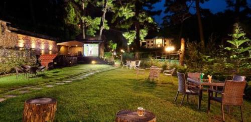 a yard with tables and chairs at night at The Heritage Club - Tripura Castle Hotel and Spa in Shillong
