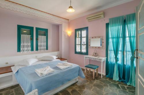 Schlafzimmer mit einem Bett, einem Tisch und einem Spiegel in der Unterkunft Nefeli Hotel Leros in Agia Marina
