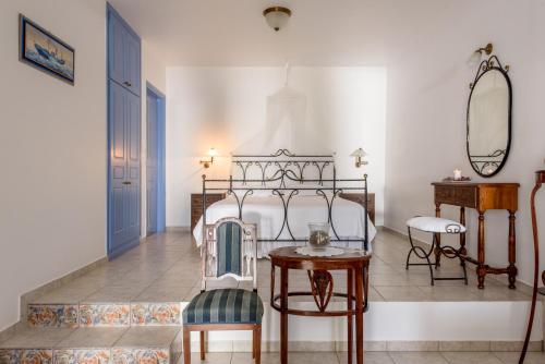 a bedroom with a bed and a table and a mirror at Villa Notos in Adamantas