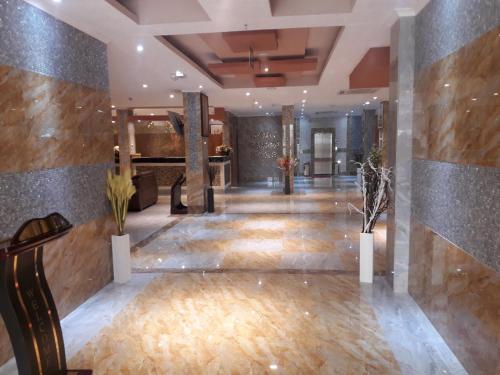 a lobby of a hotel with a marble wall at Tiffany Diamond Hotels LTD - Makunganya in Dar es Salaam