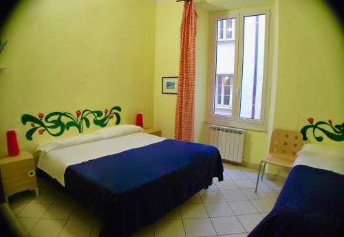 - une chambre avec 2 lits et une fenêtre dans l'établissement Albergo Teatro, à La Spezia