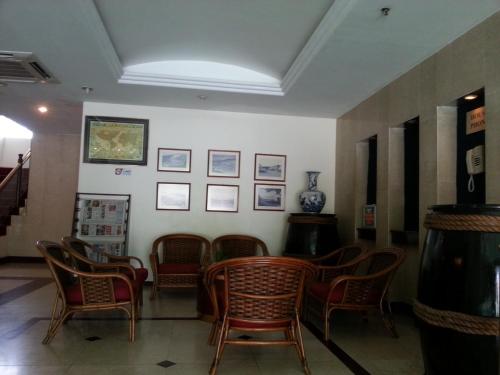a waiting room with chairs and pictures on the wall at Pacific Orient Hotel ( 凯富大酒店 ) in Miri