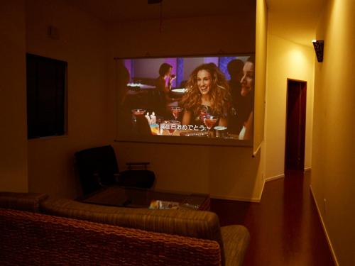 a living room with a tv with a woman on it at T&T MOF-Maeda Ocean Front House- in Onna