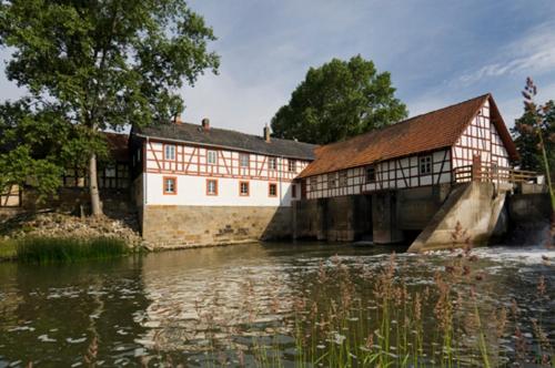 an old building next to a river with water at Ferienhof "Die Schenkenau" in Bodelstadt