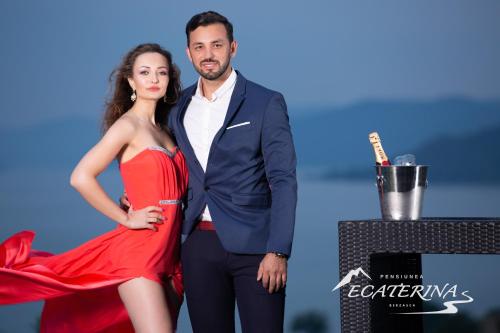 a man and a woman in a red dress standing next to a microphone at Pensiunea Ecaterina in Berzasca