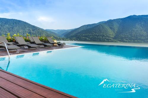 a swimming pool with a view of the water and mountains at Pensiunea Ecaterina in Berzasca