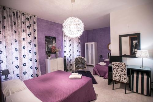 Fioletowa sypialnia z 2 łóżkami i żyrandolem w obiekcie Sant'Antonio Garden Rooms Apartments w mieście Nicolosi