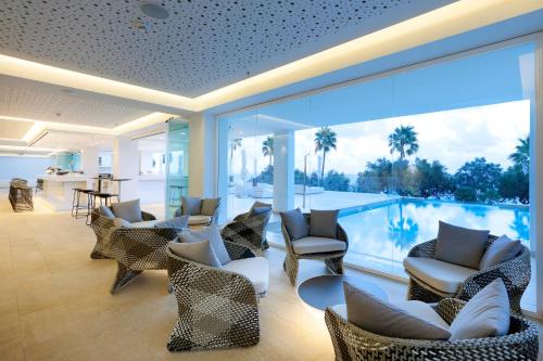 a living room with chairs and a swimming pool at Caleia Talayot Spa Hotel - Adults Only in Cala Millor