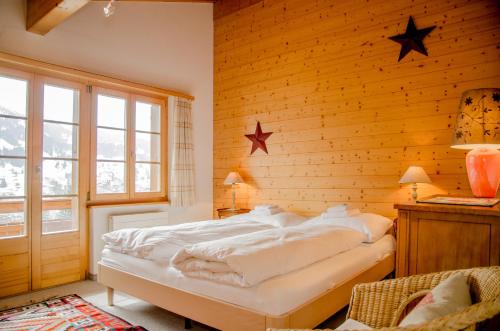 ein Schlafzimmer mit einem Bett in einer Holzwand in der Unterkunft Apartment Bärhag - GRIWA RENT AG in Grindelwald