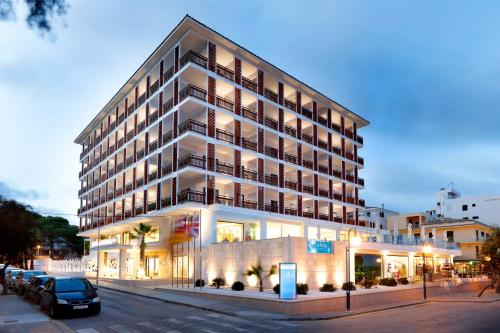 a large building with a parking lot in front of it at Talayot - Adults Only in Cala Millor