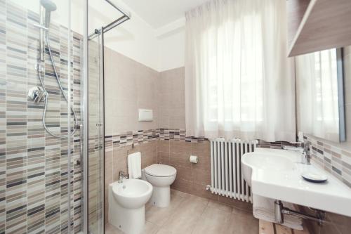 a bathroom with a toilet and a sink and a shower at Luccainn in Lucca