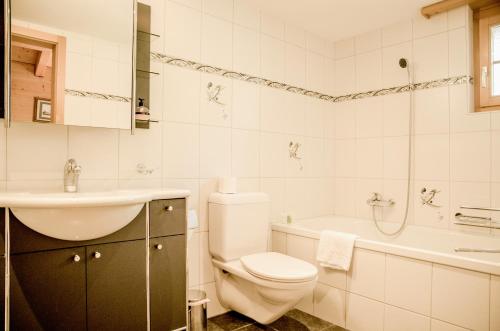 ein Badezimmer mit einem WC, einem Waschbecken und einer Badewanne in der Unterkunft Apartment Chamonix - GRIWA RENT AG in Grindelwald