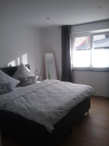 Un dormitorio con una cama grande y una ventana en Ferienwohnung Burry, en Kapellen-Drusweiler