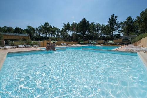 2 personnes debout dans l'eau dans une piscine dans l'établissement Le Domaine des Pins, à Saint-Hilaire-de-Riez