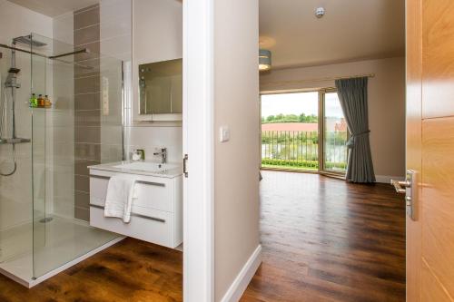 a bathroom with a sink and a glass shower at The Dinney Holiday Cottages in Bridgnorth