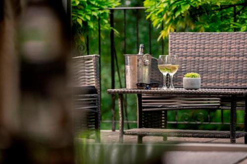 a table with two glasses of wine on it at The Grange at Oborne in Sherborne