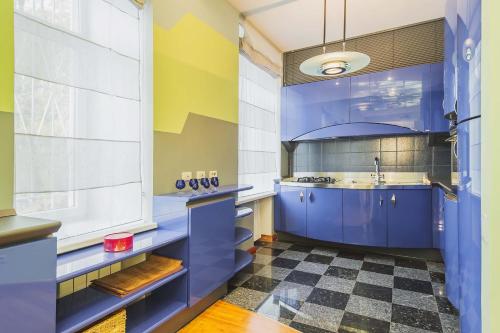 モスクワにあるGMApartments 4 rooms designer flatの青いキャビネットとチェッカーフロア付きのキッチン