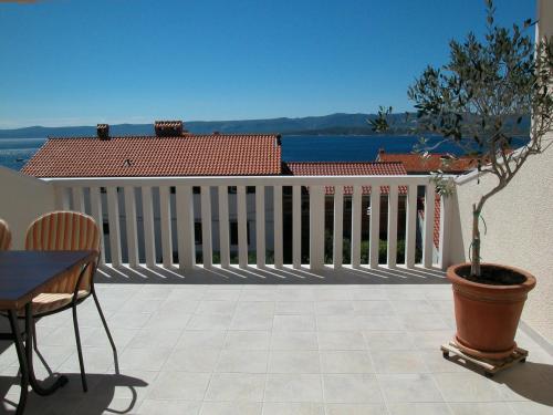 a balcony with a white fence and a potted tree at Apartments & Rooms Luna in Bol