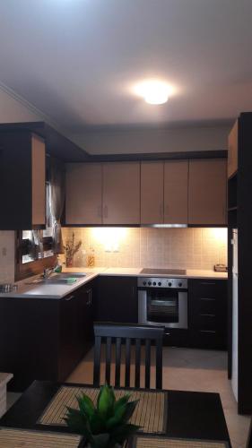 a kitchen with brown cabinets and a stove top oven at Agnanti Villas in Nafpaktos