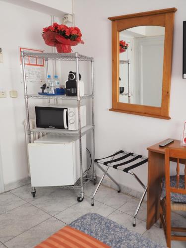 a room with a microwave and a shelf with a mirror at Hotel Montserrat in Sitges