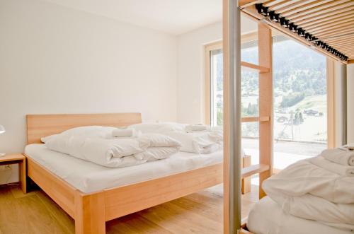 een slaapkamer met een bed met witte lakens en een ladder bij Chalet Eigerlicht - GRIWA RENT AG in Grindelwald