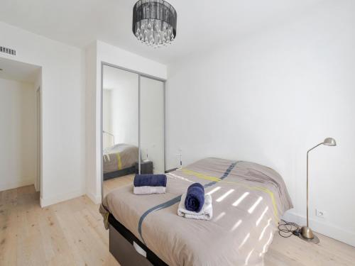 a bedroom with a bed and a large mirror at Welkeys - Delille Apartment in Nice