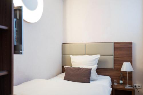 レラハにあるBASE II - Das Bed & Breakfast bei Basel (Lörrach)のベッドルーム1室(ベッド1台、ヘッドボード、枕付)