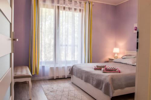 sypialnia z łóżkiem i dużym oknem w obiekcie Luxury Apartment Bursztynowa w Gdańsku