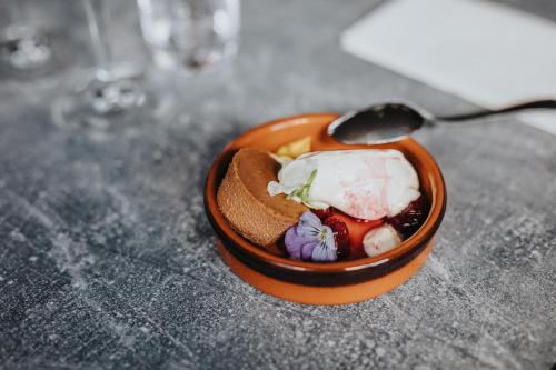 a small bowl of food with a spoon on a table at Best Western Valhall Park Hotell in Ängelholm