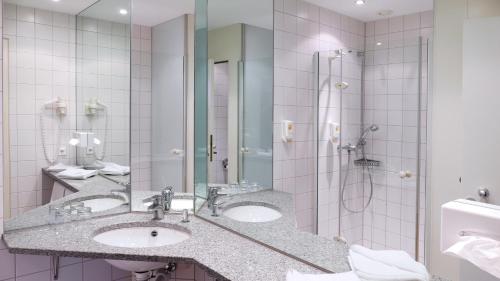 ein Bad mit 2 Waschbecken und einer Dusche in der Unterkunft Central Hotel Löwen in Feldkirch