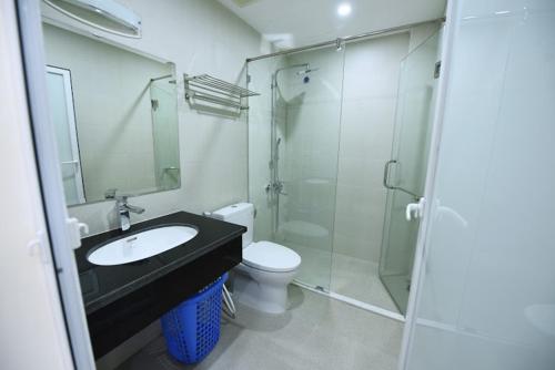 uma casa de banho com um lavatório, um WC e um chuveiro em Granda Legend Apartment em Hanói