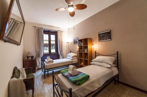 sypialnia z 2 łóżkami i wentylatorem sufitowym w obiekcie Piazza Bologna w Rzymie