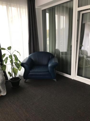 a blue leather chair in a room with windows at Casa Mario in Baile Felix