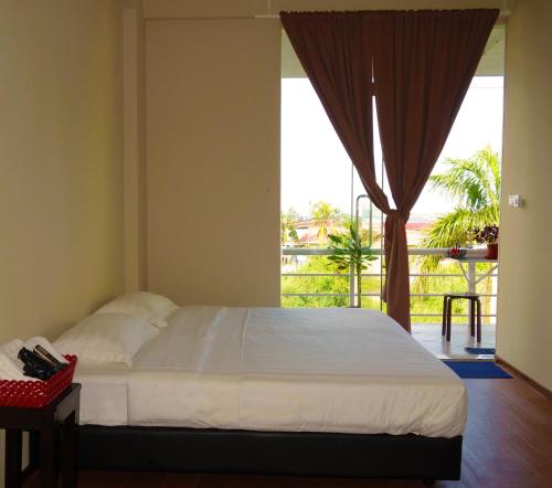 a bedroom with a bed and a large window at AE Semporna Guesthouse 极潜旅店 in Semporna