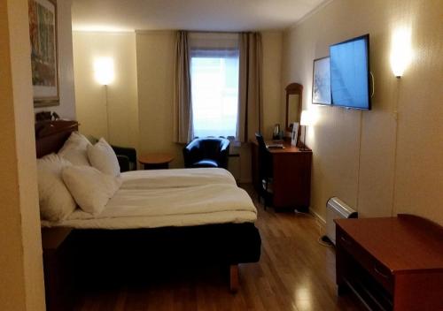 a hotel room with a bed and a desk at Chesterfield Hotel in Trondheim