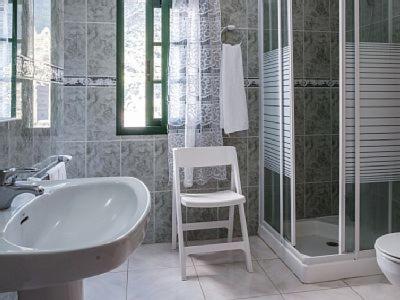 y baño con bañera, lavamanos y silla. en Casita Canaria, en Santa Cruz de Tenerife