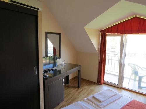 a bedroom with a desk with a television and a window at Family Hotel Dayana Beach in Sinemorets