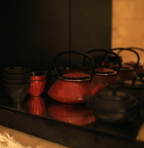 a group of red tea pots and bowls on a table at 66 Saint Paul's & Spa in Valletta