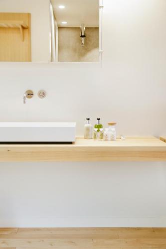 a bathroom counter with a sink and a mirror at Hôtel & Restaurant Le Pré in Durtol