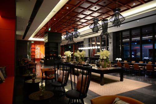 un comedor con mesas y sillas y un restaurante en Prince Times Hotel, en Sihanoukville