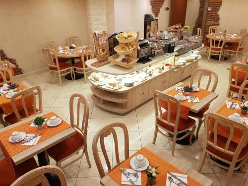 a restaurant with tables and chairs and a buffet at Hotel Champerret Elysees in Paris