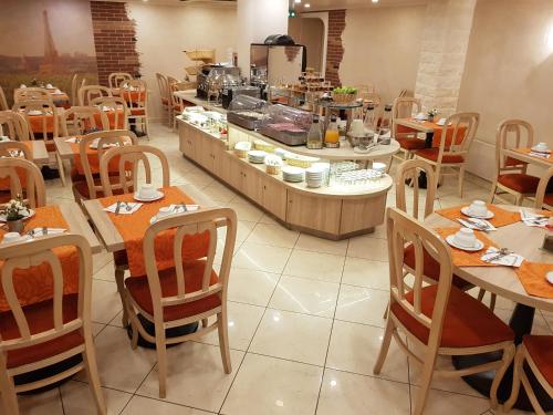 a restaurant with tables and chairs and a kitchen at Hotel Champerret Elysees in Paris