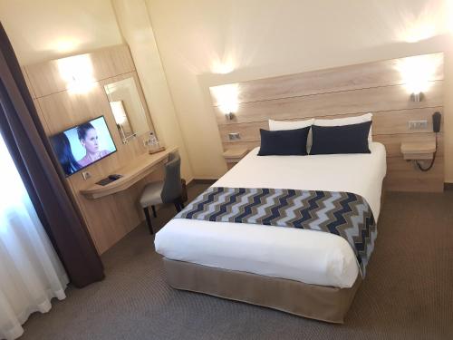 a hotel room with a bed and a television at Hotel Champerret Elysees in Paris
