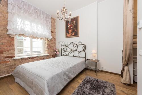a bedroom with a large bed and a brick wall at Vip Rotermanni Apartment in Tallinn