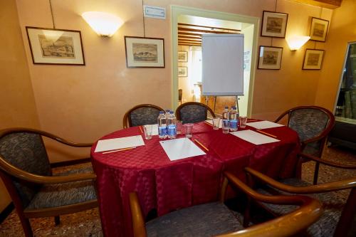 a dining room with a red table and chairs at Hotel Riviera dei Dogi in Mira