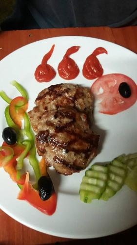 a plate of food with meat and vegetables on a table at Family Hotel Dayana Beach in Sinemorets