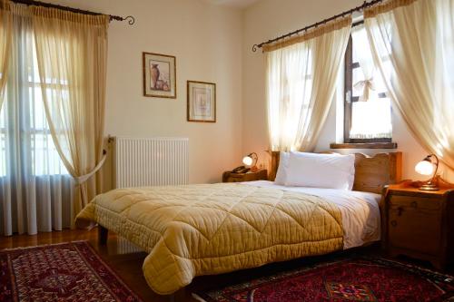 Livadero的住宿－Petrini Gonia，一间卧室设有一张床和两个窗户。