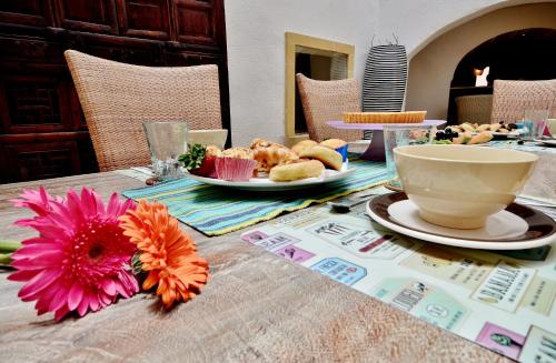 a table with a plate of food and a cup on it at Chapel 5 Boutique Suites B&B in Naxxar