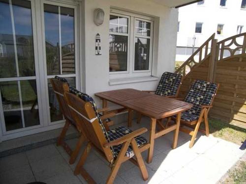 a wooden table and chairs on the porch of a house at Seepark Bansin App 101 in Bansin