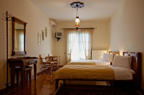 um quarto com uma cama, uma mesa e uma janela em Petrini Gonia em Livadero
